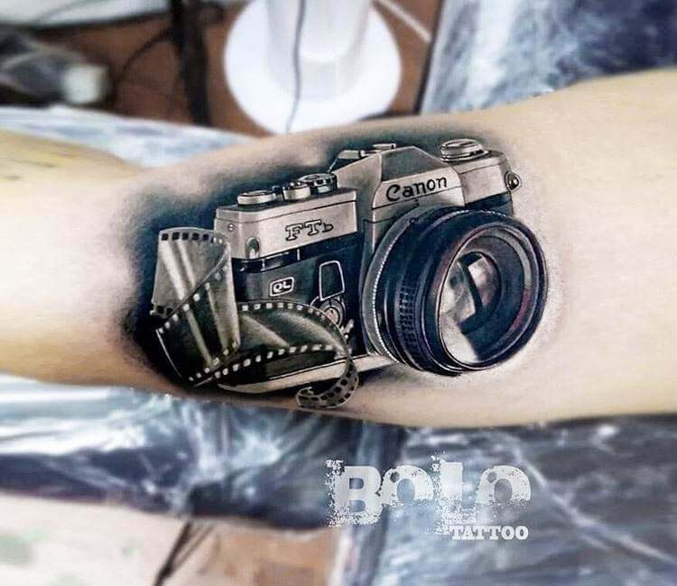 Camera lens rose tattoo on the calf