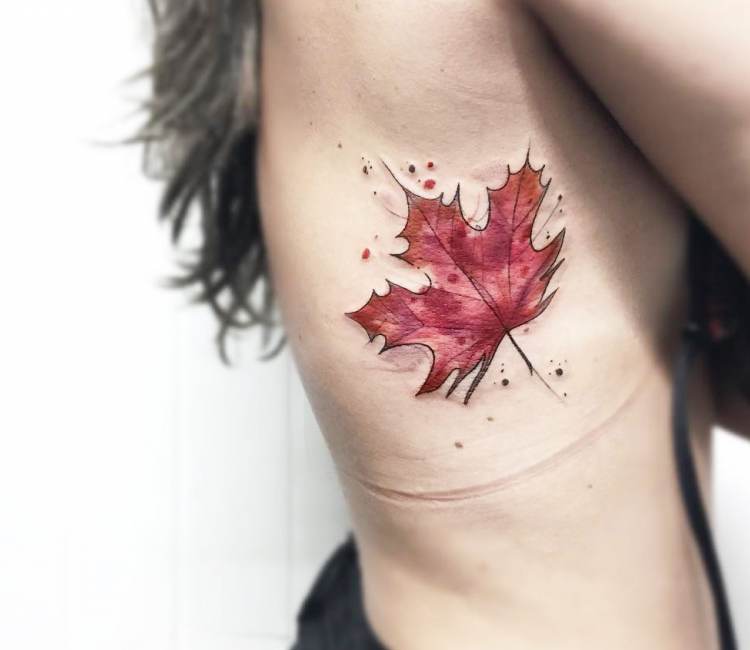 Small maple leaf tattoo located on the back.