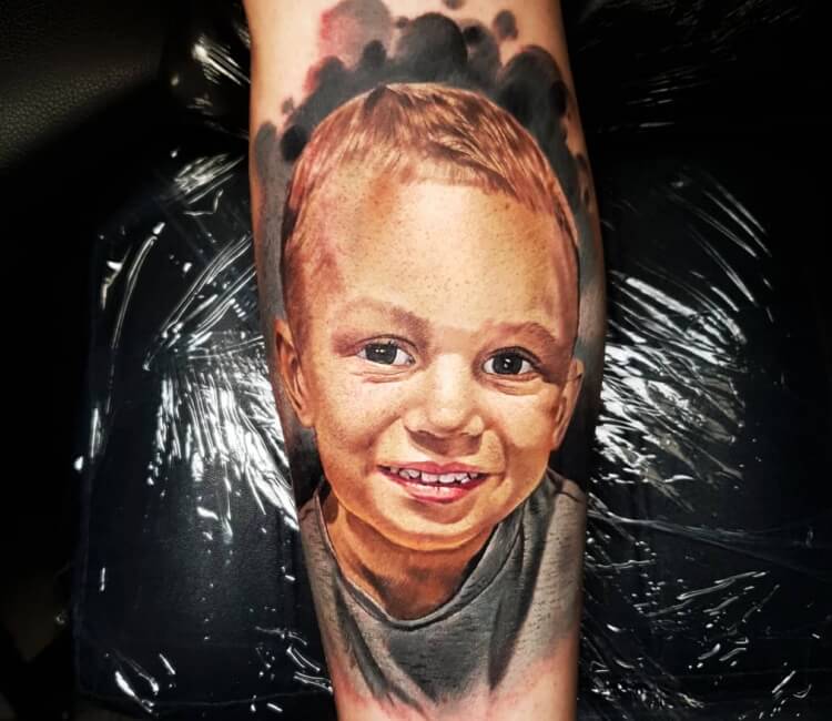 Black and grey baby portrait tattoo on the right thigh
