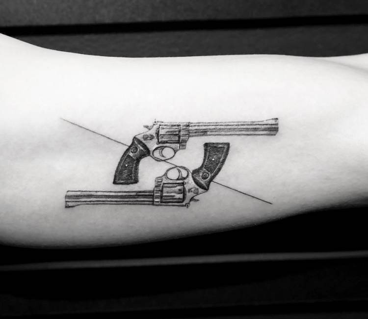 Tattoo of a pistol located on the ankle.