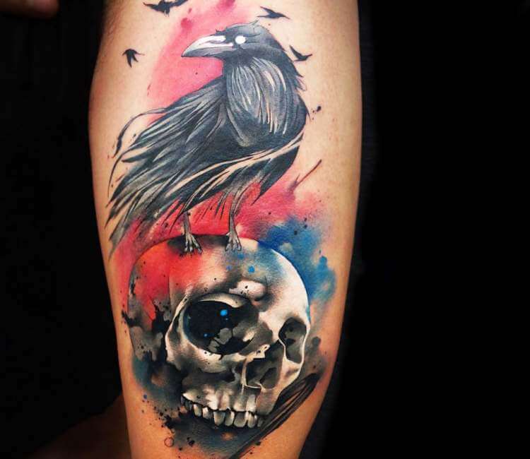 Deer skull and raven tattoo on the left upper arm